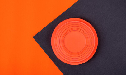 Orange clay target on black and orange geometric background. Skeet shooting - 435842994