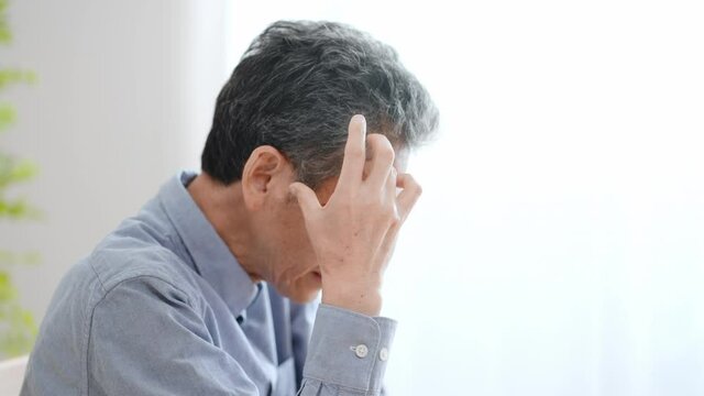悩む高齢の男性