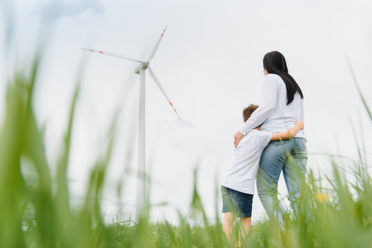 Alternative energy, wind farm and happy time with your family. Happy mother on the road with his son on vacation and escape to nature.