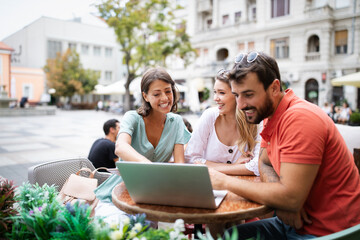 Friends at cafe talking laughing and enjoying their time using digital tablet.