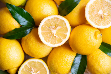 Fototapeta na wymiar Fresh and ripe lemons with leaves on white wooden table
