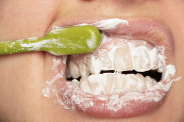 female teeth in toothpaste brushing teeth close-up