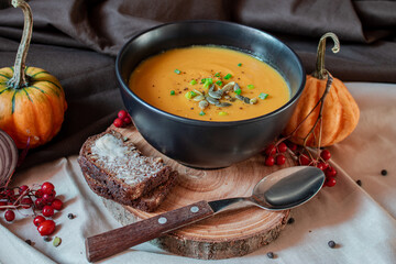 Pumpkin cream soup on wooden plate