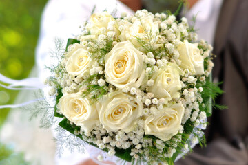 Beautiful wedding bouquet in hands of the bride and groom