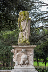 Headless ancient roman sculpture decorating Villa Borghese garden in Rome
