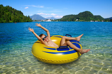 Little boy on inflatable ring in the lake .