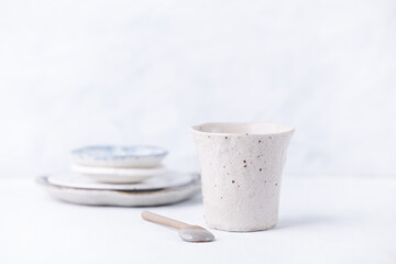 Traditional, handcrafted ceramic on bright wooden background. Soft focus. Close up. Copy space.