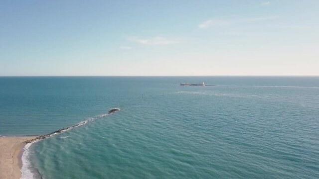 Panorama Of Blue Sea With Sancti-Petri Breakwater And  Castle In The Distance In Chiclana de la Frontera, Spain. - aerial