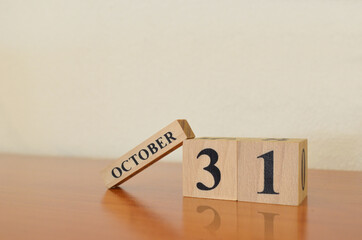 October 31, Date design with calendar cube on wooden table and white background.