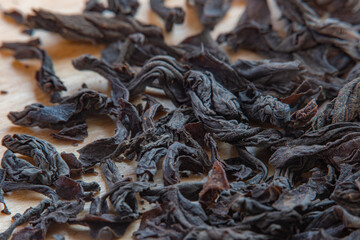 Close-up of a pile of dry black tea leaves in soft focus at high magnification. Dry plants for the...