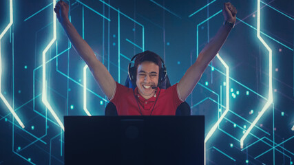 Professional eSports Gamer Playing in Computer Video Games, Happily and Cheerfully Celebrates Victory and Success with Raised Hands. Online Cyber Championship / Tournament. Portrait View © Gorodenkoff