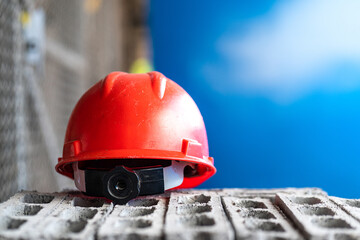 A red safety working helmet for supervisor PIC (person in charge) is placed on the brick block....