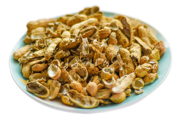 A pile of peanut shells in a plate. Closeup of leftover food in soft focus.