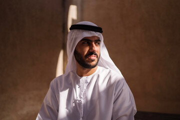 Portrait of arab man wearing dishdash kandura standing in historical disctrict