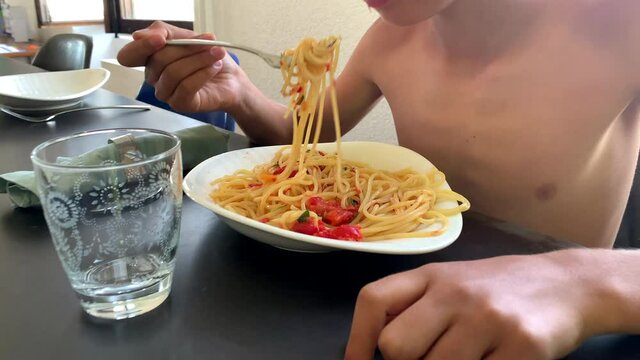 Young boy eating pasta. Child eats spaghetti