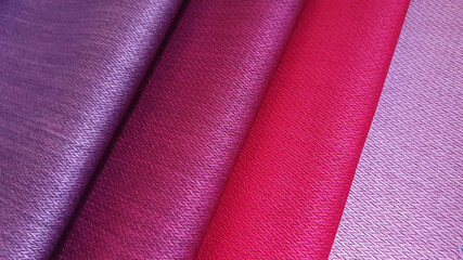 fabric organza texture in pink ,violet ,purple and red color tone. close up woolen fabric for interior drapery and upholstery works. satiny fabric sample swatch.