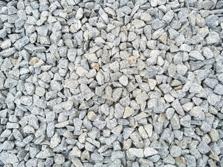Gray gravel background with copy space. The natural texture of grey stones. Rough stone background. Grunge backdrop with textured pebbles.