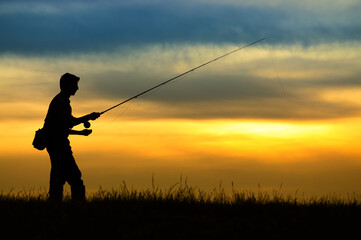 Silhouette of fisherman in sunset.