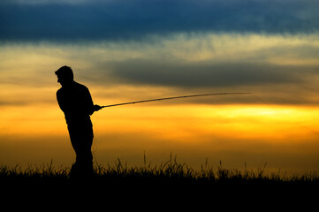 Silhouette of fisherman in sunset.