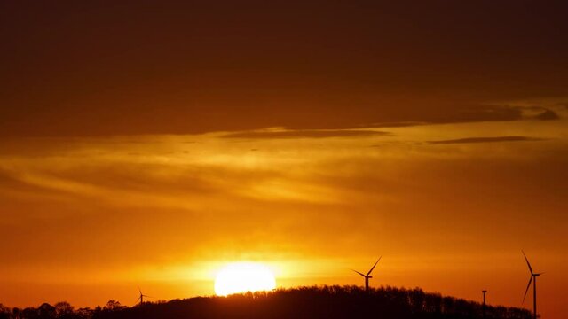 Sunrise on the background of wind power generators, time lapse