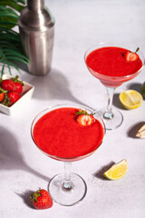 Cold strawberry margarita or daiquiri cocktail with lime and rum