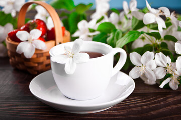Fototapeta na wymiar Cup of tea with white apple blossoms. Spring concept.