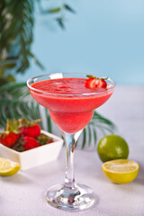 Cold strawberry margarita or daiquiri cocktail with lime and rum