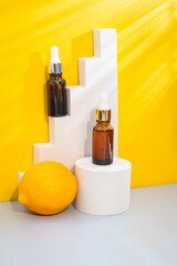 Glass cosmetic bottle with oil or serum for skin care on special podium on yellow background. Natural skin care concept.