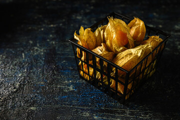 Physalis in a food container on a dark aged background