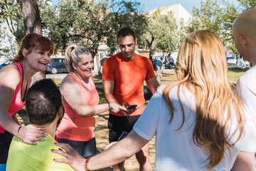 Group of people with sportswear talking distractedly in a park