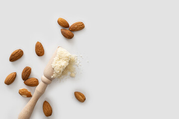 almond flour with nuts scattered on white background, gluten free product, keto food, top view,...