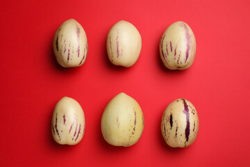 Fresh ripe pepino melons on red background, flat lay