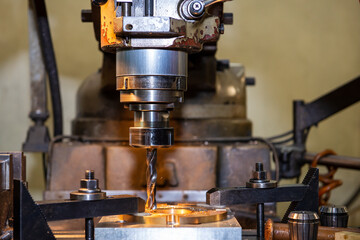 The hole drilling processing by drill tool on NC milling machine. The shop floor operation by NC milling machine.