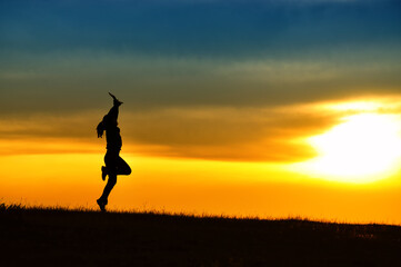Fototapeta na wymiar Silhouette of girl jumping in sunset.