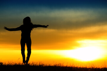 Fototapeta na wymiar Silhouette of girl jumping in sunset.