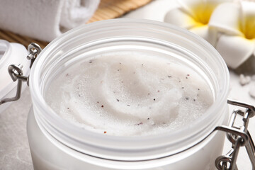 Body scrub in glass jar on table, closeup