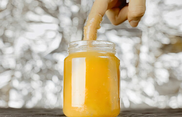 Plunging a finger in a jar of yellow honey. Visual metaphor for a certain type of sexual...