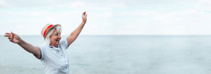 Panoramic horizontal summer sale banner with beautiful woman in a straw hat at the seaside during summer vacation. Happy girl with blond hair enjoying the sun on the seascape background