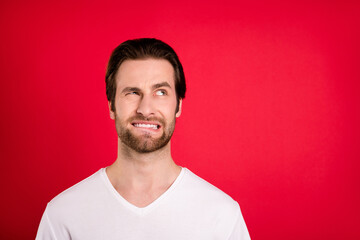 Photo of unhappy upset young man look empty space problem bad mood isolated on red color background
