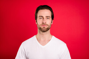 Obraz premium Photo of strict young brown hairdo man wear white t-shirt isolated on vivid red color background