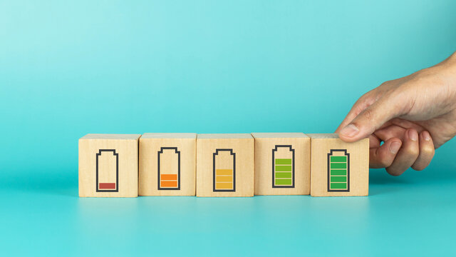 Hand hold wooden cube with full level energy battery green. Concept of work motivation, employee growth