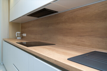 Modern kitchen interior with induction hob and faucet with sink
