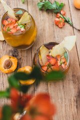 drink in a glass with red flowers on a wooden background