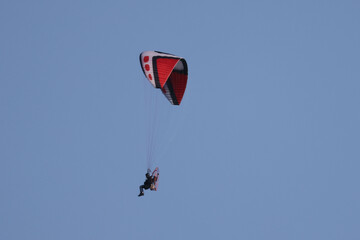 Motorized hang gliders in evening light over countryside  in spring