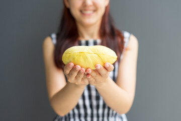 Close up A woman handle durian show the yellow durian meat to eat. The durian is a king of fruit of Thailand.