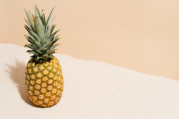 fresh pineapple on the sand of a tropical beach in summer. Travel and holiday concept background. copy space.