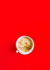 Morning hot cup of black coffee with milk and foam on red background. Top view. Flat lay.