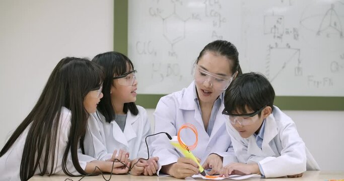 Asian teacher having 3d drawing lesson to elementary students in class. Science and education.