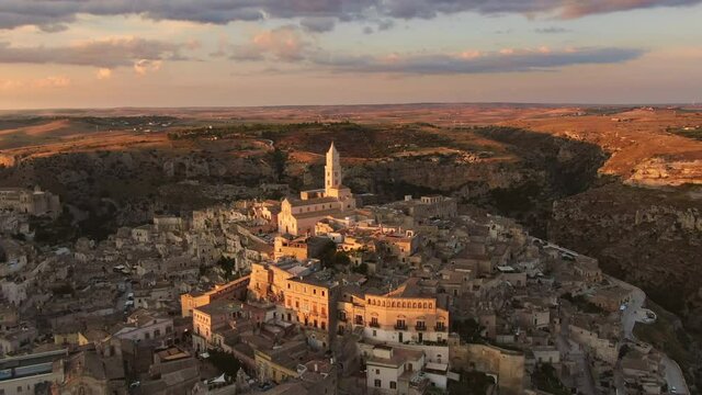 sassi di matera historic town aerial view,drone flying forward over old city center at dusk sunset