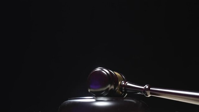 A judge is hitting gavel off a block in courtroom. Gavel is being struck to decide an auction or guilty verdict in court